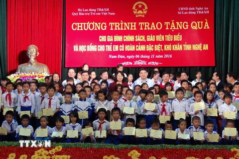 Phó Chủ tịch nước Đặng Thị Ngọc Thịnh chụp ảnh lưu niệm cùng các trẻ em có hoàn cảnh đặc biệt khó khăn của huyện Nam Đàn. (Ảnh: Tá Chuyên/TTXVN) 