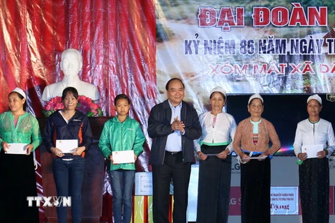 Thủ tướng Nguyễn Xuân Phúc tặng quà cho các gia đình có hoàn cảnh khó khăn ở xóm Mát, xã Dân Chủ, thành phố Hòa Bình. (Ảnh: Thống Nhất/TTXVN) 