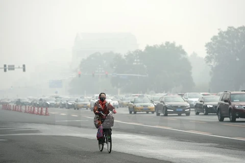 Người dân Trung Quốc đeo khẩu trang để tránh tác hại của khói mù ô nhiễm tại thủ đô Bắc Kinh, Trung Quốc ngày 14/10. (Nguồn: THX/TTXVN)