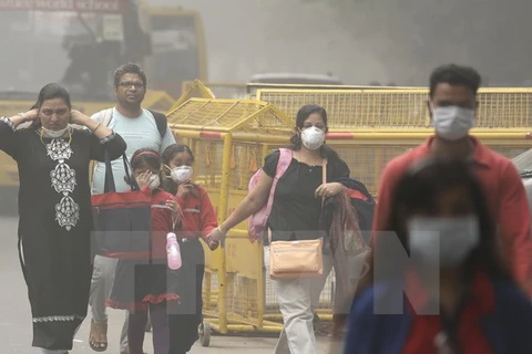 Người dân đeo khẩu trang để tránh tác hại của khói mù ô nhiễm ở New Delhi, Ấn Độ. (Nguồn: AP/TTXVN)