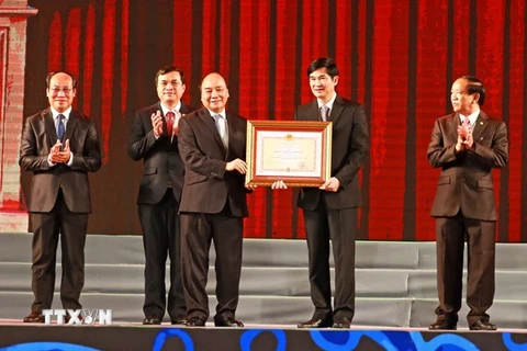Thủ tướng Nguyễn Xuân Phúc thừa ủy quyền Chủ tịch nước trao tặng Huân chương Độc lập hạng Nhất cho tỉnh Quảng Nam. (Ảnh: Thống Nhất/TTXVN)