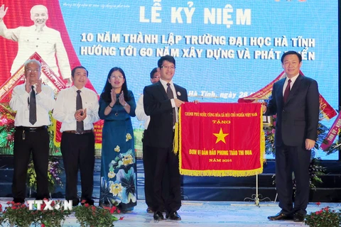 Phó Thủ tướng Vương Đình Huệ tặng Cờ thì đua của Chính phủ cho nhà trường. (Ảnh: Công Tường/TTXVN)