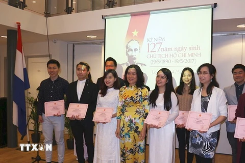 Đại sứ Ngô Thị Hoà trao bằng khen cho 17 sinh viên Việt Nam có thành tích xuất sắc. (Ảnh: Định Hương/TTXVN)