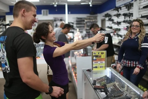Một khách hàng nữ thử súng tại cửa hàng bán vũ khí tại Pompano Beach, Florida. (Ảnh: AFP)