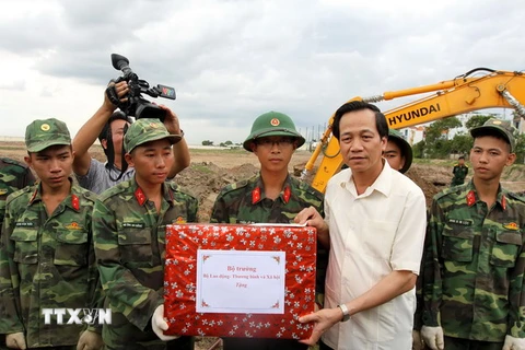 Bộ trưởng Đào Ngọc Dung tặng quà động viên lực lượng tìm kiếm hài cốt liệt sĩ tại sân bay Tân Sơn Nhất. (Ảnh: Thanh Vũ/TTXVN)