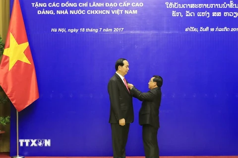 Đồng chí Phankham Viphavan, Ủy viên Bộ Chính trị,Thường trực Ban Bí thư Đảng NDCM Lào, Phó Chủ tịch nước Lào trao tặng Huân chương Vàng Quốc gia của Đảng, Nhà nước Lào cho Chủ tịch nước Trần Đại Quang. (Ảnh: Nhan Sáng/TTXVN)