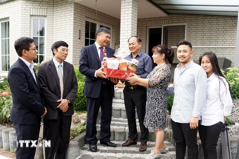 Đại sứ quán Việt Nam tại Đức Đoàn Xuân Hưng thăm, tặng quà gia đình anh Trương Định có bố và mẹ đều là liệt sỹ. (Ảnh: Phạm Văn Thắng/TTXVN)
