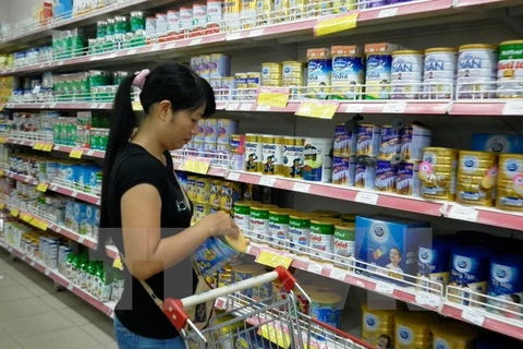 Khách hàng chọn mua sữa bình ổn giá tại Siêu thị Co.op Mart Thanh Hà. (Ảnh: Lan Phương/TTXVN)