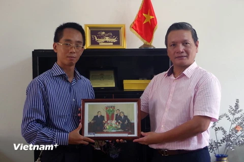 Đại diện TTXVN trao tặng ảnh về quan hệ Việt Nam-Algeria cho Đại sứ Phạm Quốc Trụ. (Ảnh: Quang Trường/Vietnam+)