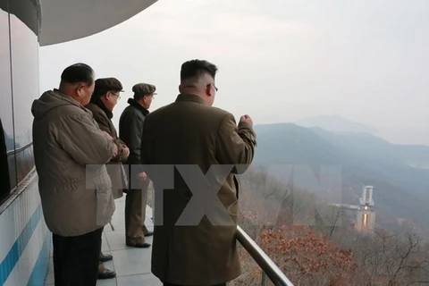 Nhà lãnh đạo Triều Tiên Kim Jong-un (phải) theo dõi việc thử động cơ tên lửa tại một địa điểm bí mật ngày 19/3. (Nguồn: EPA/TTXVN)