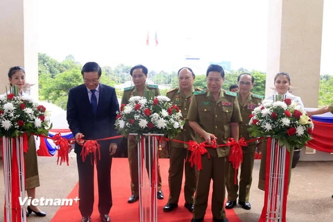 Đại sứ Nguyễn Bá Hùng và Thiếu tướng Songvang Thammasith, Thứ trưởng Bộ An ninh Lào cắt băng khai mạc triển lãm. (Ảnh: Phạm Kiên/Vietnam+)