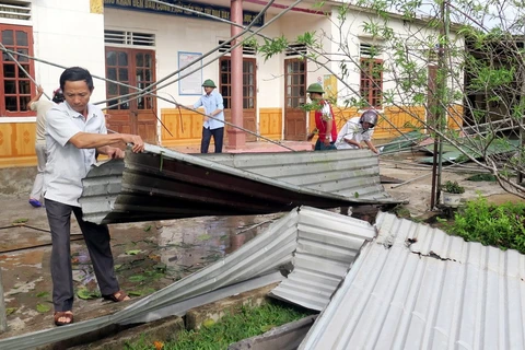 Phụ huynh học sinh và các thầy cô giáo trường Tiểu học xã Hộ Độ, huyện Lộc Hà, Hà Tĩnh tập trung khắc phục hậu quả do bão số 10 gây ra. (Ảnh: Công Tường/TTXVN)