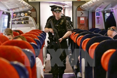 Cảnh sát đặc nhiệm Anh tuần tra trên chuyến tàu tới nhà ga Euston ở London. (Nguồn: AFP/TTXVN)