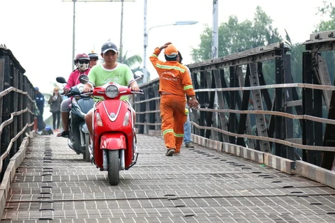 Người dân đôi bờ sông Phước Kiểng lưu thông qua lại cầu Long Kiểng. (Ảnh: Trần Xuân Tình/TTXVN)