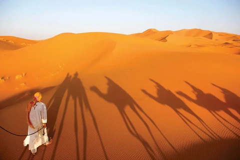 Mohamed và cái bóng của “những người bạn” in trên nền cát lúc ráng chiều. 
