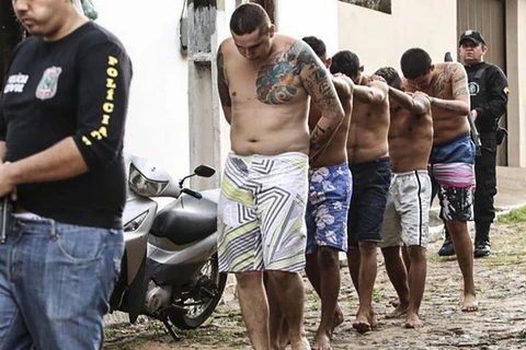 Cảnh sát áp giải các tù nhân sau một vụ bạo loạn nhà tù ở Brazil . (Nguồn: EPA/TTXVN)