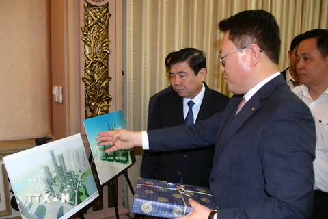 Chủ tịch UBND Thành phố Hồ Chí Minh Nguyễn Thành Phong và Tổng Giám đốc Điều hành Công ty Lotte Asset Development Lee Kwang Young trao đổi về phối cảnh dự án. (Ảnh: Tiến Lực/TTXVN)