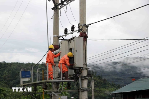 Cán bộ nhân viên kỹ thuật của công ty điện Nậm Nhùn (Mường Tè) kiểm tra, khắc phục sự cố hệ thống lưới điện bị thiệt hại do mưa lũ gây ra tại Trung tâm xã Mường Tè. (Ảnh: Quý Trung/TTXVN)