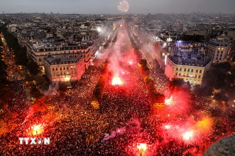 Người dân mừng chiến thắng của đội tuyển Pháp tại World Cup 2018 ở đại lộ Champs Elysées, thủ đô Paris, Pháp ngày 15/7. (Ảnh: AFP/ TTXVN)