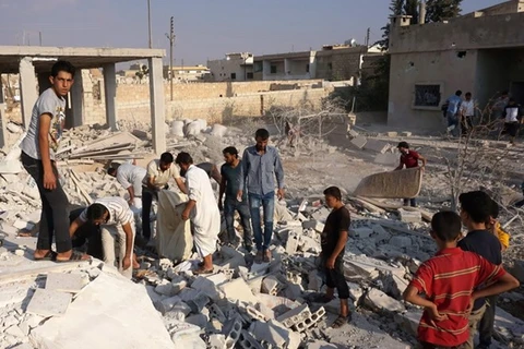 Tìm kiếm các nạn nhân dưói những đống đổ nát sau vụ không kích tại tỉnh Idlib. (Nguồn: AFP/TTXVN)