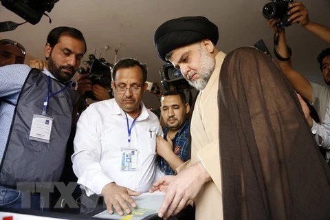 Thủ lĩnh cộng đồng người Hồi giáo dòng Shiite Moqtada al-Sadr (giữa, phải) bỏ phiếu tại điểm bầu cử ở thành phố Najaf. (Nguồn: AFP/TTXVN)
