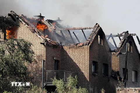 Nhiều ngôi nhà bị cháy rụi sau vụ hỏa hoạn gần tuyến đường sắt cao tốc ở thành phố Siegburg, miền tây Đức ngày 7/8. (Ảnh: AFP/TTXVN)