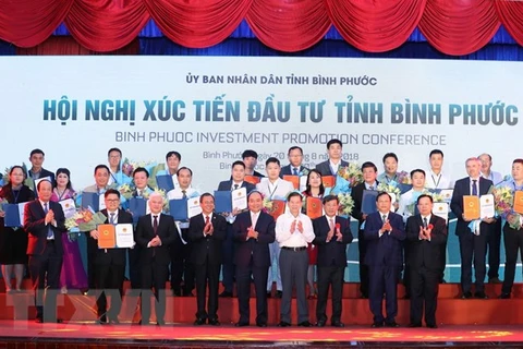 Thủ tướng Nguyễn Xuân Phúc chụp ảnh chung với các doanh nghiệp nhận giấy chứng nhận đăng ký đầu tư, quyết định chủ trương đầu tư vào tỉnh Bình Phước. (Ảnh: Thống Nhất/TTXVN)