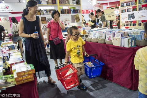Các em bé thích thú cùng bố mẹ đi chọn mua sách tại hội chợ sách quốc tế ở Bắc Kinh, Trung Quốc. (Nguồn: news.cgtn)