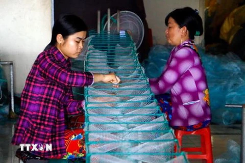 Người dân làng lưới Thơm Rơm tất bật sản xuất hàng phục vụ nhu cầu đánh bắt thủy sản trong mùa lũ. (Ảnh: Thanh Liêm/TTXVN)