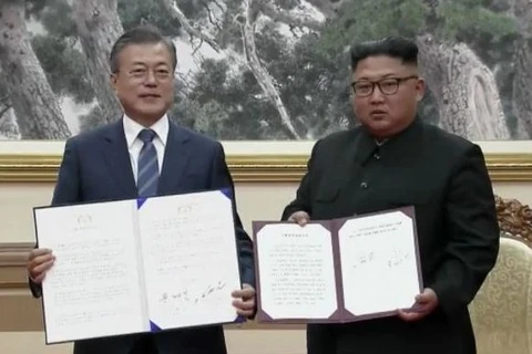 Nhà lãnh đạo Triều Tiên Kim Jong-un (phải) và Tổng thống Hàn Quốc Moon Jae-in (trái) ký vào văn kiện thống nhất ra tuyên bố chung. (Nguồn: KBS)