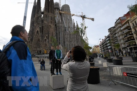 Du khách tham quan thành phố Barcelona. (Ảnh: AFP/TTXVN)