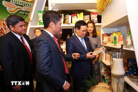 Phó Thủ tướng Vương Đình Huệ, Bộ trưởng Bộ Công thương Trần Tuấn Anh tham quan các gian hàng trưng bày sản phẩm gạo. (Ảnh: Danh Lam/TTXVN)