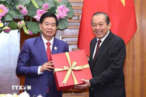 Phó Thủ tướng thường trực Trương Hòa Bình tặng quà lưu niệm cho Đô trưởng Thủ đô Vientiane, ông Sinlavong Khoutphaythoune. (Ảnh: Dương Giang/TTXVN)