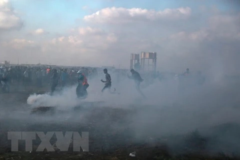 Binh sỹ Israel bắn đạn hơi cay về phía người biểu tình Palestine gần khu vực biên giới Gaza-Israel. (Nguồn: THX/TTXVN)