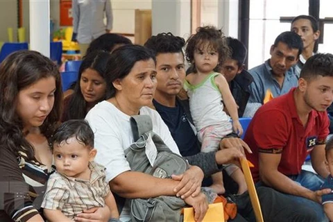 Người nhập cư chờ được hỗ trợ tại một trung tâm nhân đạo ở thị trấn McAllen, bang Texas, Mỹ ngày 14/6. (Ảnh: AFP/TTXVN)