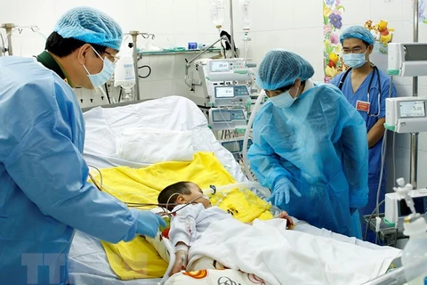 Bộ trưởng Bộ Y tế Nguyễn Thị Kim Tiến thăm bệnh nhi Ly Chương Bình, 7 tuổi được ghép phổi. (Ảnh: Dương Ngọc/TTXVN)