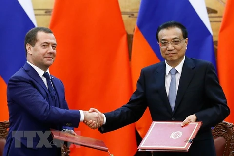 Thủ tướng Trung Quốc Lý Khắc Cường (phải) và Thủ tướng Nga Dmitry Medvedev (trái) tại lễ ký các thỏa thuận hợp tác song phương ở Bắc Kinh, Trung Quốc ngày 7/11/018. (Ảnh: AFP/TTXVN)