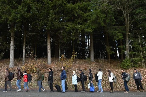 Người tị nạn chờ xe buýt sau khi vượt qua khu vực biên giới giữa Áo và Đức ở Wegscheid, miền nam Đức. (Nguồn: AFP/TTXVN)