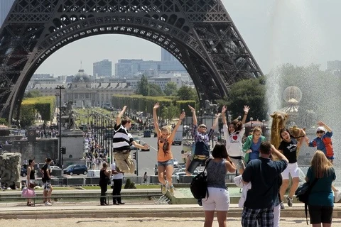 Khách du lịch bên Tháp Eiffel ở Paris (Pháp). (Nguồn: AFP/TTXVN)