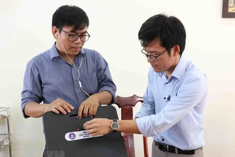 Thầy Tôn Thất Trường Nam (bên trái) và thầy Trần Quốc Lâm giới thiệu về máy phát hiện gian lận thi cử. (Ảnh: Phạm Cường/TTXVN) 