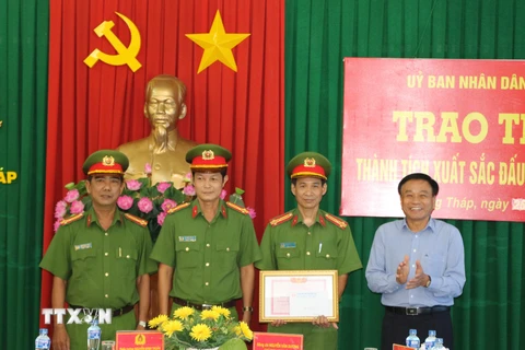 Chủ tịch UBND tỉnh Đồng Tháp Nguyễn Văn Dương trao thưởng cho 1 tập thể và các cá nhân có thành tích xuất sắc trong phá án. (Ảnh: Chương Đài/TTXVN