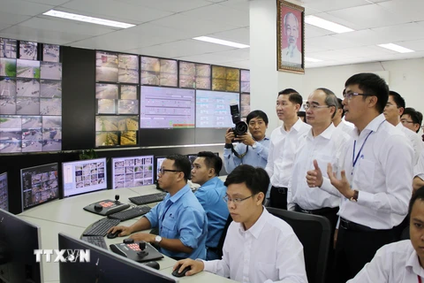 Bí thư Thành ủy Thành phố Hồ Chí Minh Nguyễn Thiện Nhân nghe báo cáo về hệ thống camera giám sát giao thông của Trung tâm điều hành giao thông thông minh. (Ảnh: Tiến Lực/TTXVN)