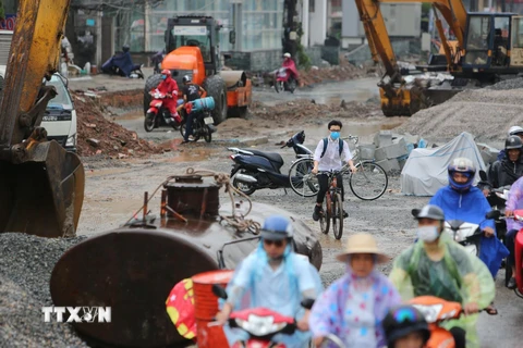 Nhiều người dân vẫn bất chấp nguy hiểm vượt chướng ngại vật, đi vào công trường mỗi khi tắc đường. (Ảnh: Thành Đạt/TTXVN)