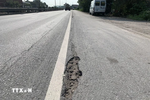 Mặt đường hằn lún vệt bánh xe và nứt vỡ nhiều điểm trên quốc lộ 5. (Ảnh: Hiền Anh/TTXVN)