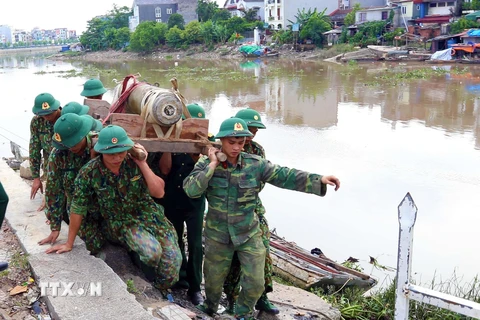 Các lực lượng chức năng di dời quả bom tại khu vực cầu mới sông Tam Bạc, khu vực phường Hạ Lý, quận Hồng Bàng tới nơi hủy nổ. (Ảnh: An Đăng/TTXVN)