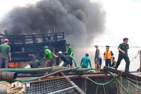 Lực lượng chức năng nỗ lực dập tắt đám cháy trên tàu. (Ảnh: Trần Thị Thu Hiền/TTXVN)