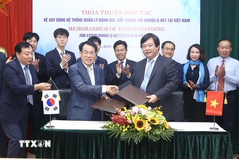 Ông Nguyễn Hồng Minh, Tổng cục trưởng Tổng cục Giáo dục nghề nghiệp và ông Mu Jang Byun, Phó chủ tịch Cơ quan Phát triển nguồn nhân lực Hàn Quốc (HRD) trao bản ký kết thoả thuận hợp tác. (Ảnh: Minh Quyết/TTXVN)