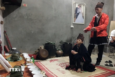 12 giờ đêm đầu tiên của lễ, đứa trẻ mới được mặc bộ trang phục của người dân tộc Dao Tiền để bắt đầu làm Lễ Đặt tên. (Ảnh: Vũ Hà/TTXVN)