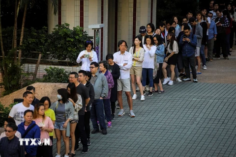 Cử tri Đặc khu hành chính Hong Kong (Trung Quốc) xếp hàng chờ bỏ phiếu tại điểm bầu cử Hội đồng cấp quận 2019 ở Hong Kong ngày 24/11/2019. (Ảnh: AFP/TTXVN)