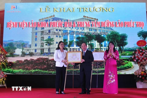 Phó Chủ tịch Ủy ban Nhân dân tỉnh Thái Bình Nguyễn Thị Lĩnh (trái) trao giấy phép hoạt động cho Bệnh viện Lão khoa Phước Hải. (Nguồn: TTXVN)